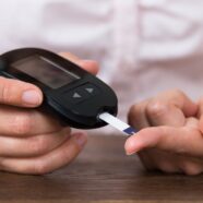 Closeup image of a woman using a blood glucose meter.