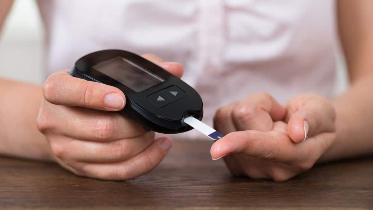 Closeup image of a woman using a blood glucose meter.