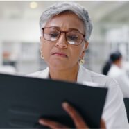 A woman in a lab coat reads about bariatric surgery for type 2 diabetes on her tablet.