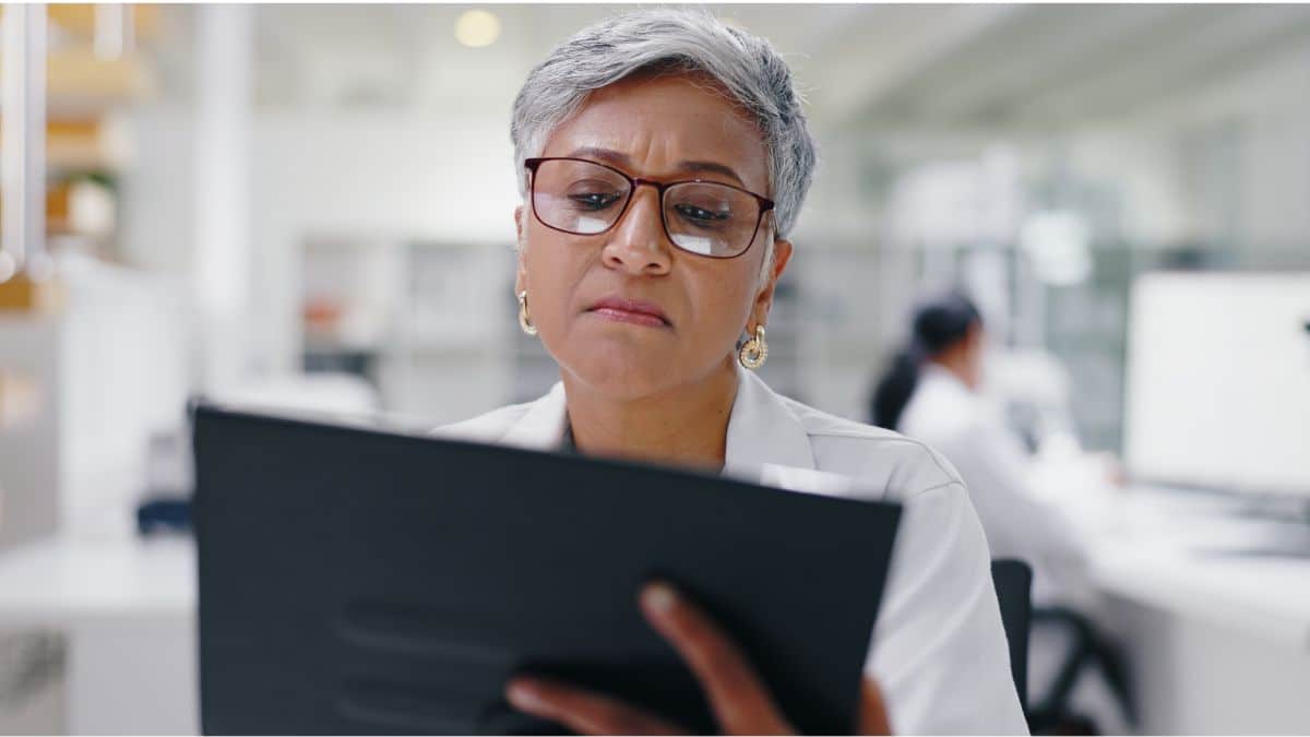 A woman in a lab coat reads about bariatric surgery for type 2 diabetes on her tablet.