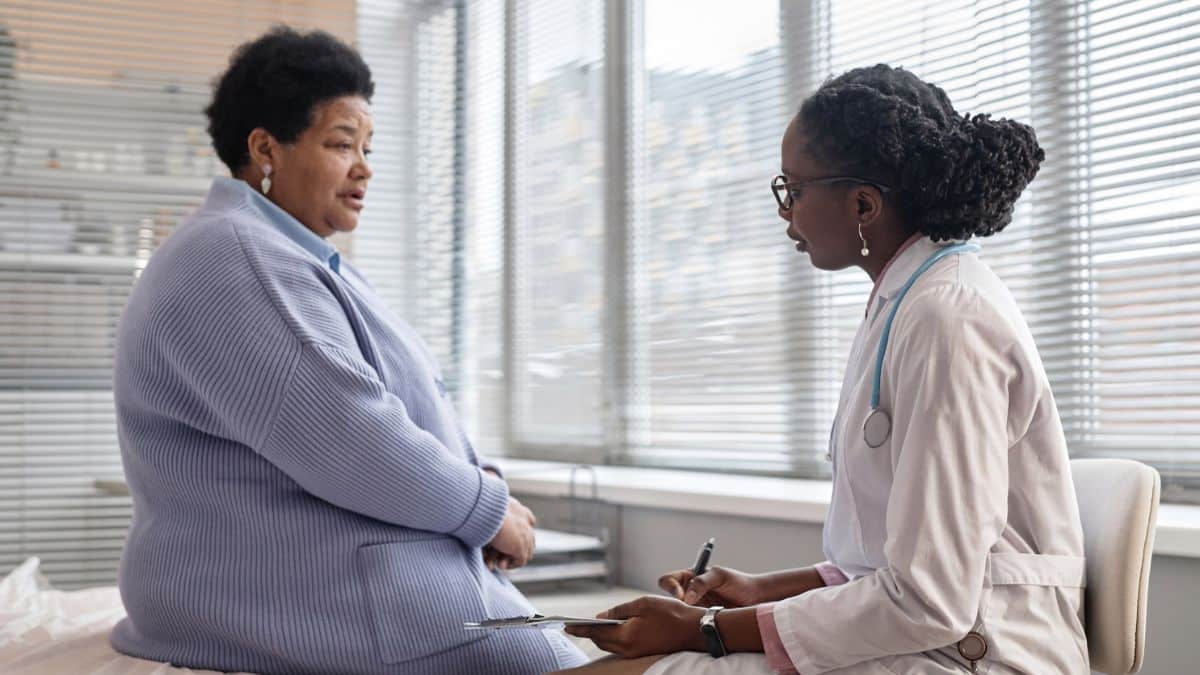 An African American endocrinologist reviews CGM data with her diabetic patient.