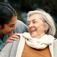 A caregiver is shown smiling at her patient.